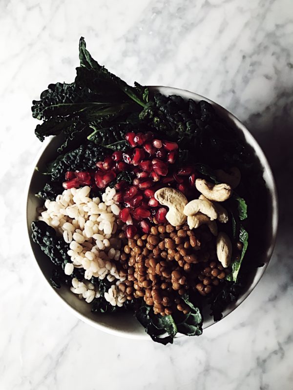 a raw kale Buddha bowl with lentils, barley, cashews and pomegranate vinaigrette
