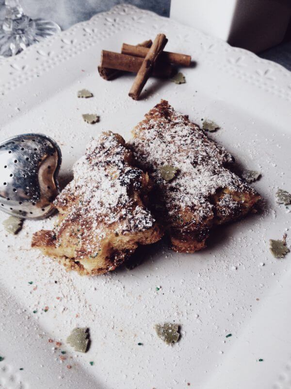 pandoro french toast shaped as a Christmas tree and sprinkled with confectionary sugar