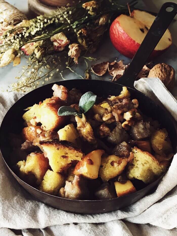 Italian sausage stuffing with apples, pandoro, walnuts, and olive oil in a pan