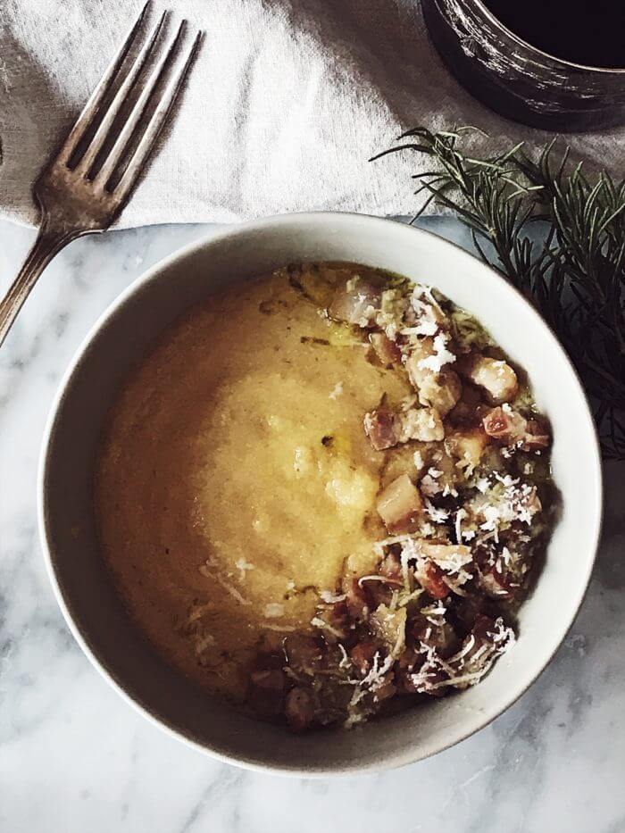 creamy polenta in a bowl with gricia sauce