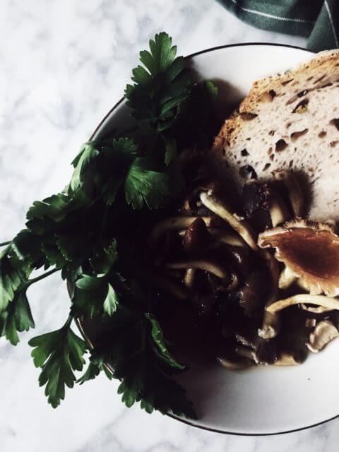 parmesan broth with mushrooms and chili oil Mushroom soup with a slice of bread and fresh parsley