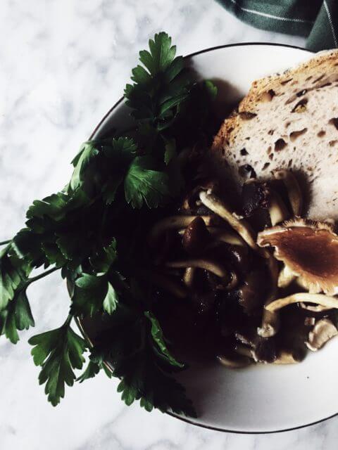 Mushroom soup with a slice of bread and fresh parsley