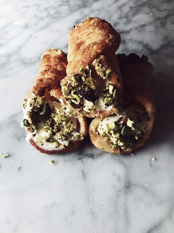 Fried pizza dough stuffed with stracchino and covered with pistachio grain