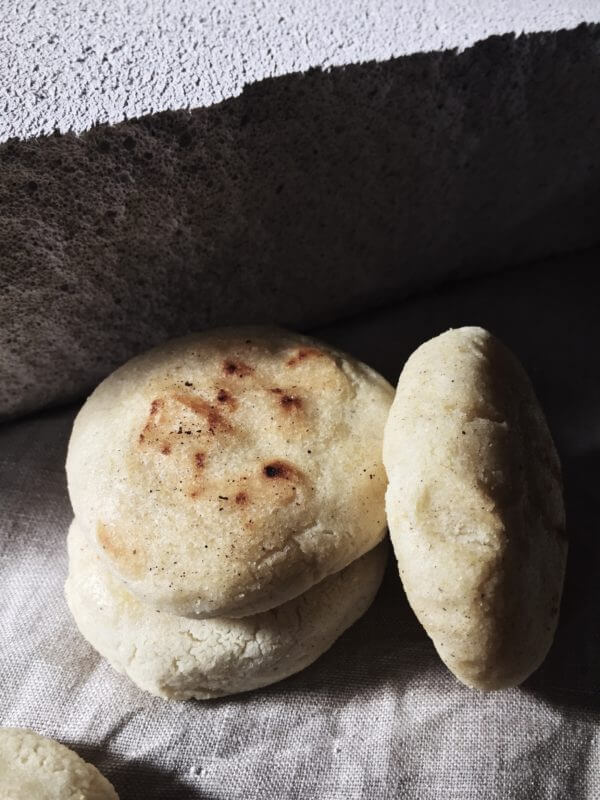 arepas recipe three patties on a grey backdrop