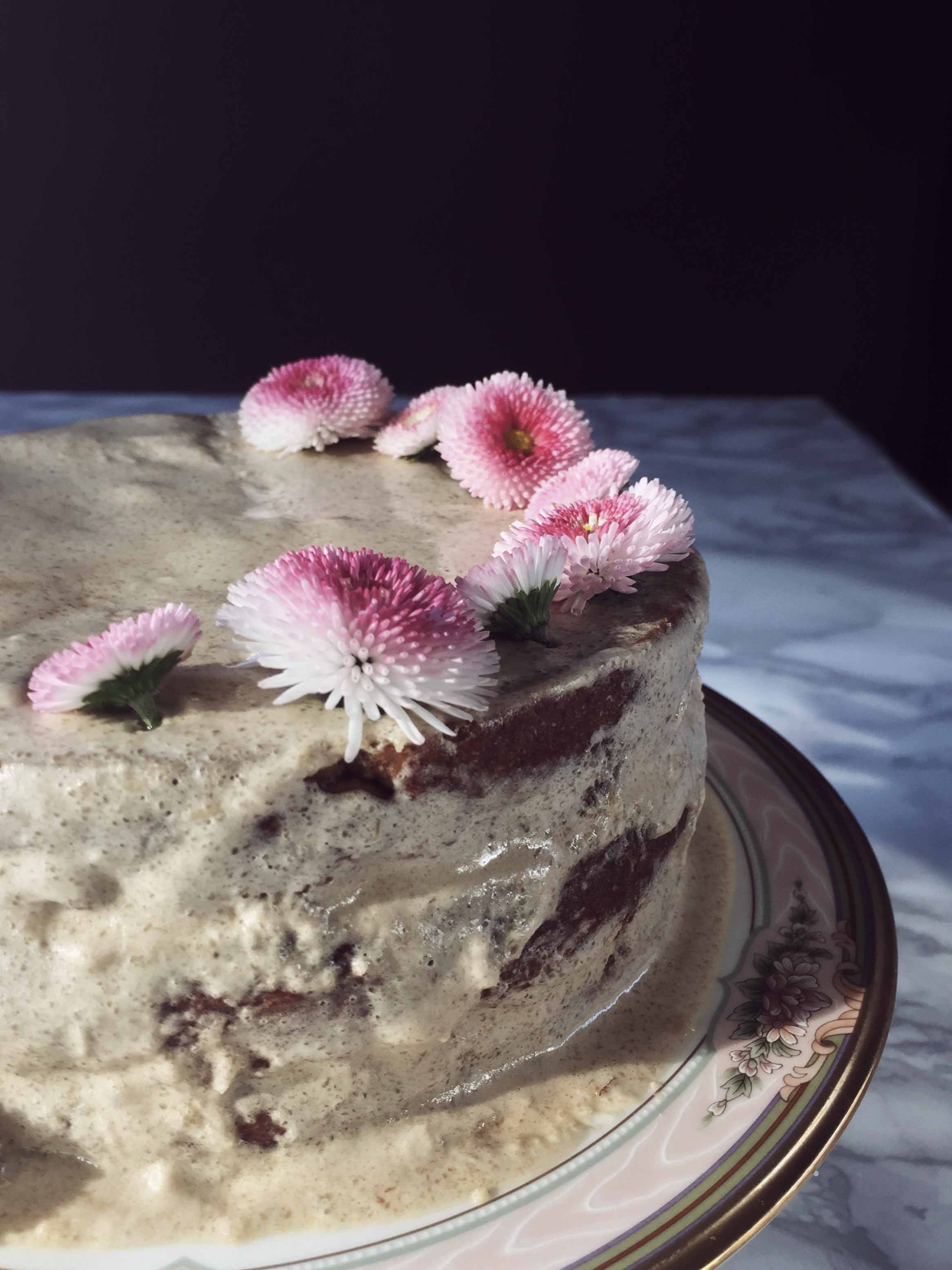 olive oil carrot cake with frosting and edible flowers