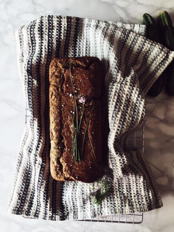 savory zucchini bread on a kitchen cloth with chives flowers