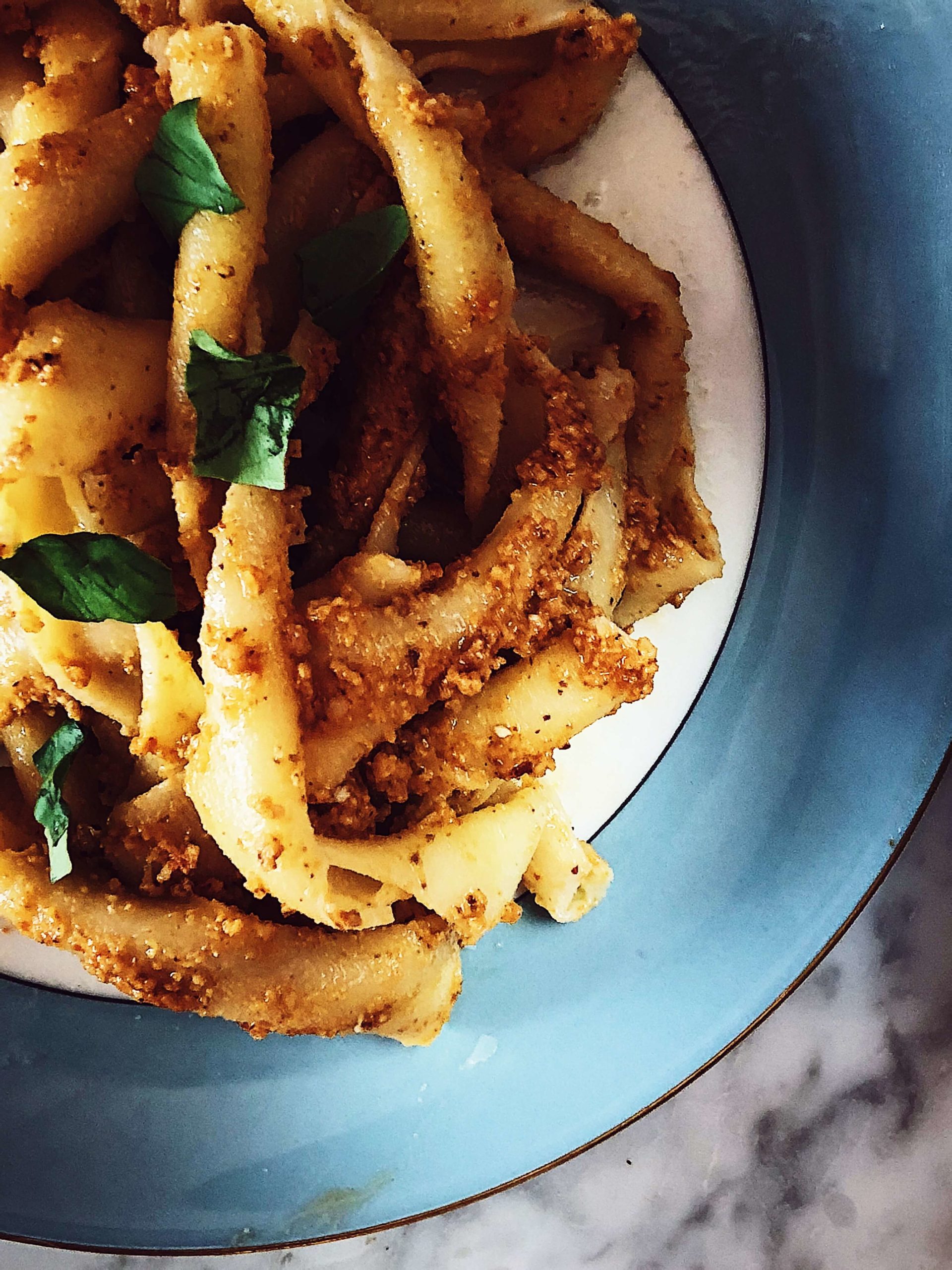 trapanese pesto pasta served on a blue plate