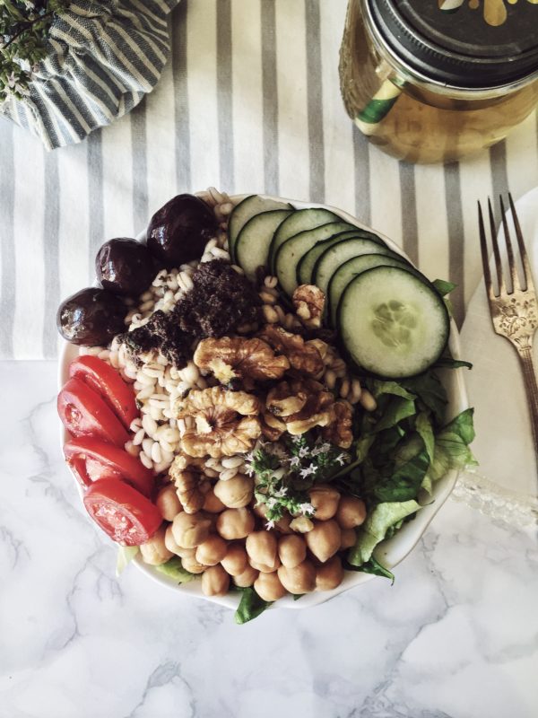 a summer buddha bowl inspired to greek cuisine: olives, oregano, chickpeas and barley