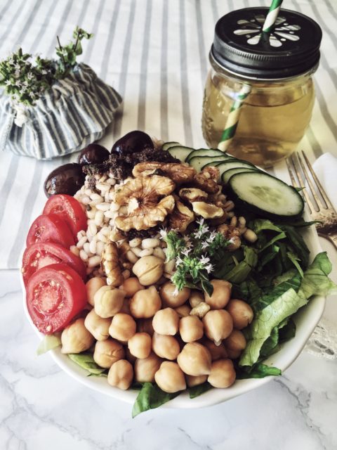 a summer buddha bowl inspired to greek cuisine: olives, oregano, chickpeas and barley