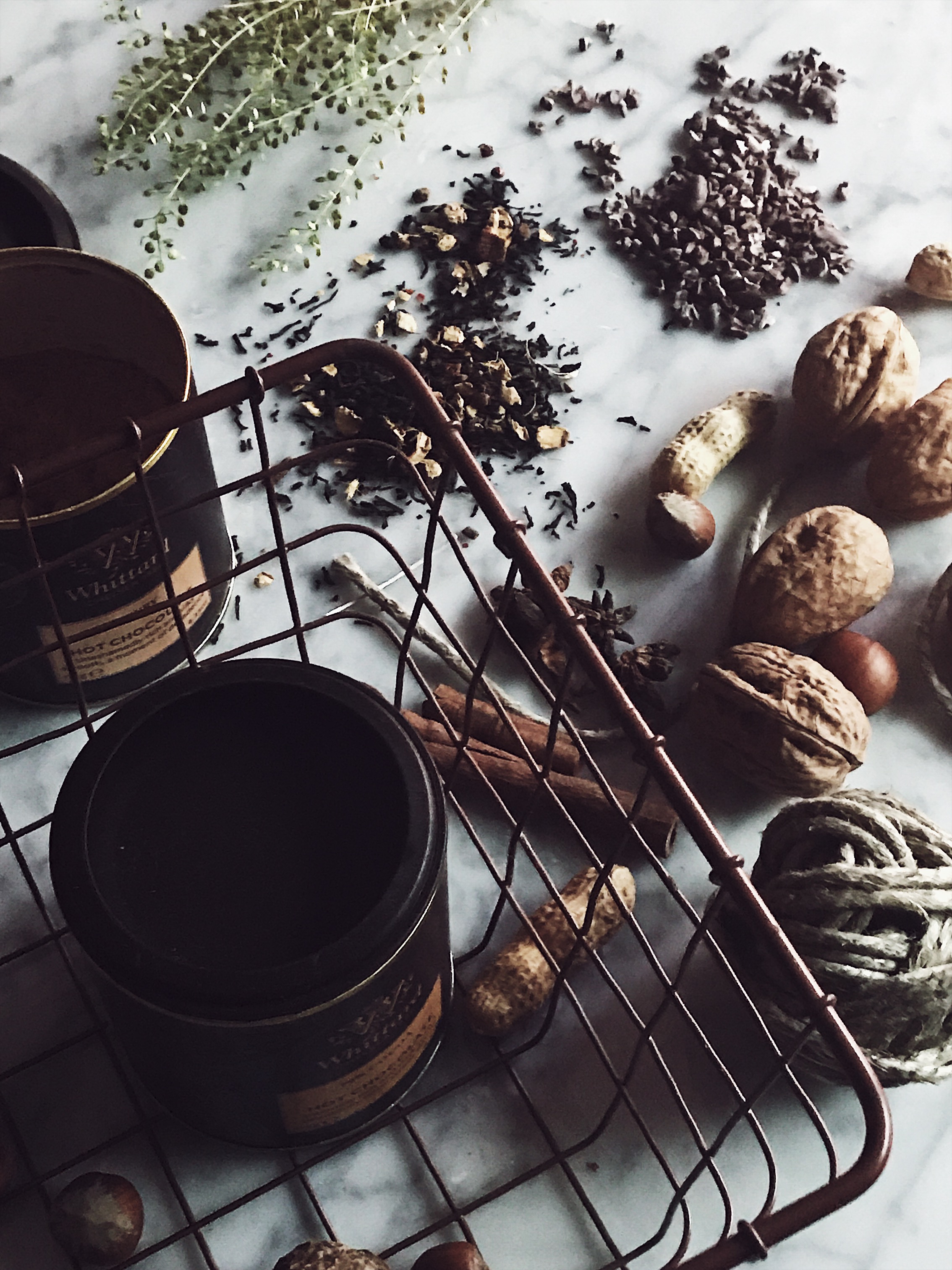 hot chocolate mix in aware basket, nuts, cinnamon and tea leaves