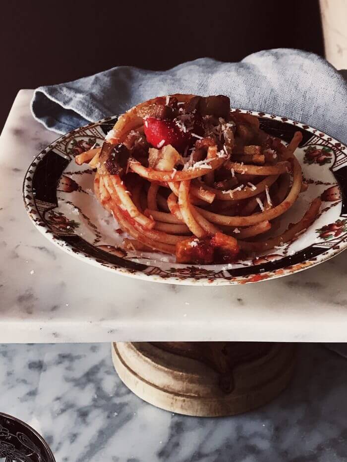 amatriciana pasta in a plate on a marble stand