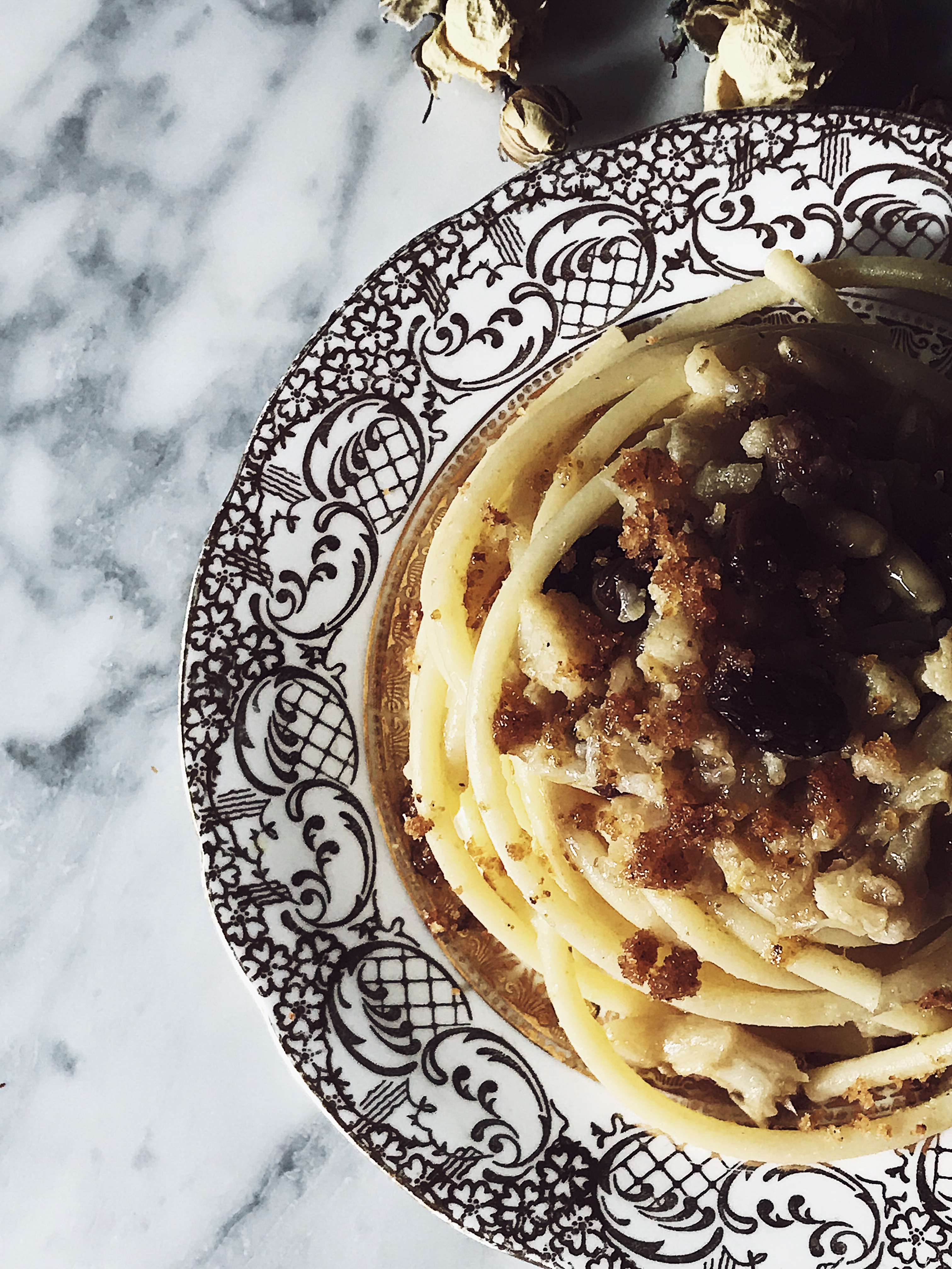 Sicilian cauliflower pasta on a marble surface and in a vintage golden plate