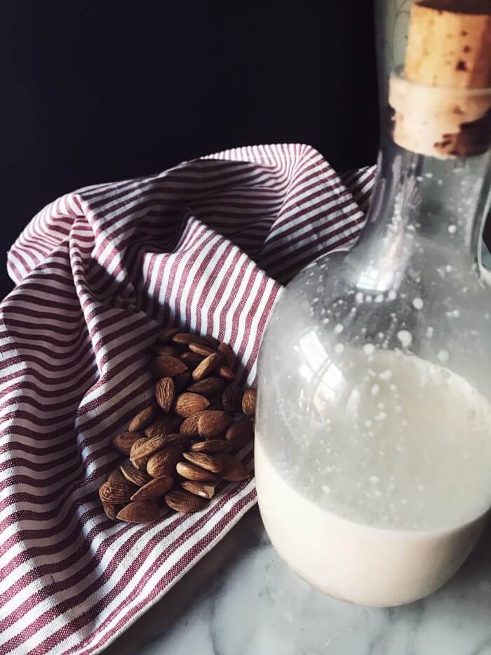 unpeeled almonds and a bottle of homemade latte di mandorla, almond milk