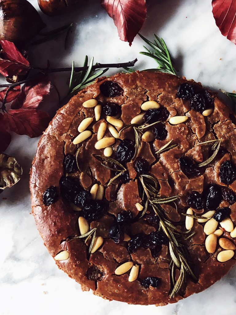 castagnaccio chestnut cake with pine nuts, raisins and rosemary on top