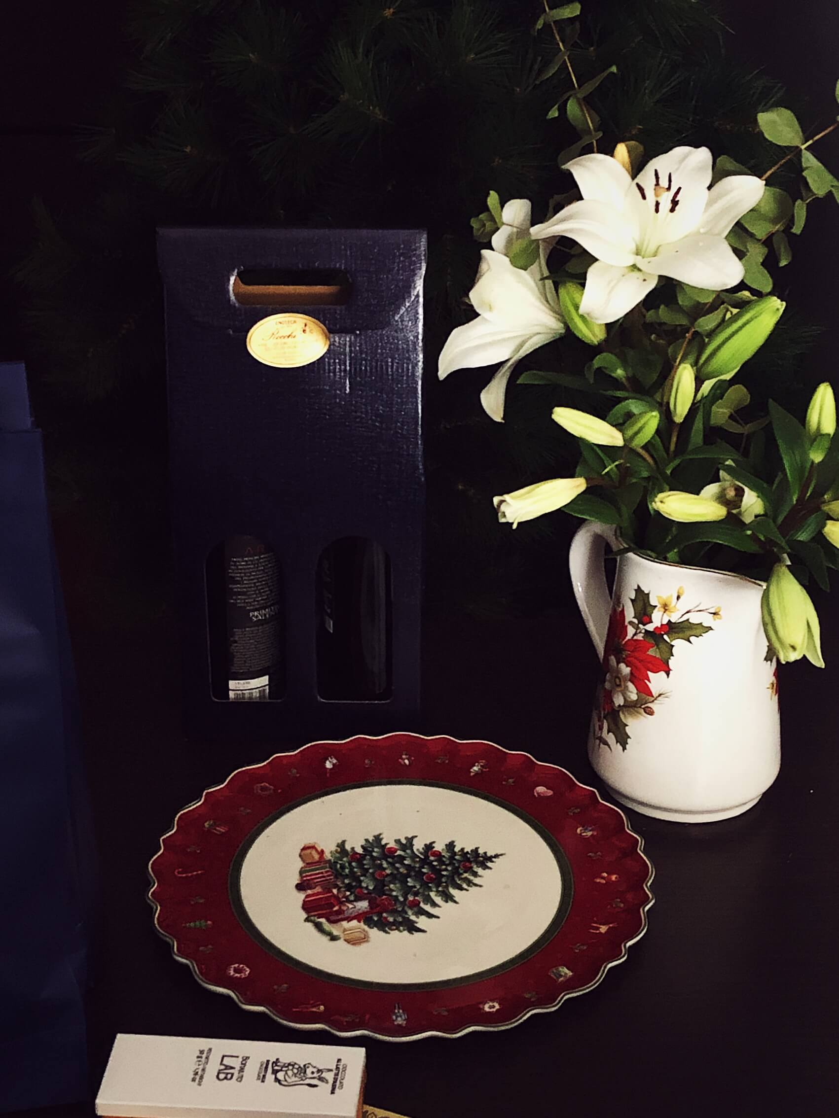 Christmas flowers, a plate, and two bottles of wine