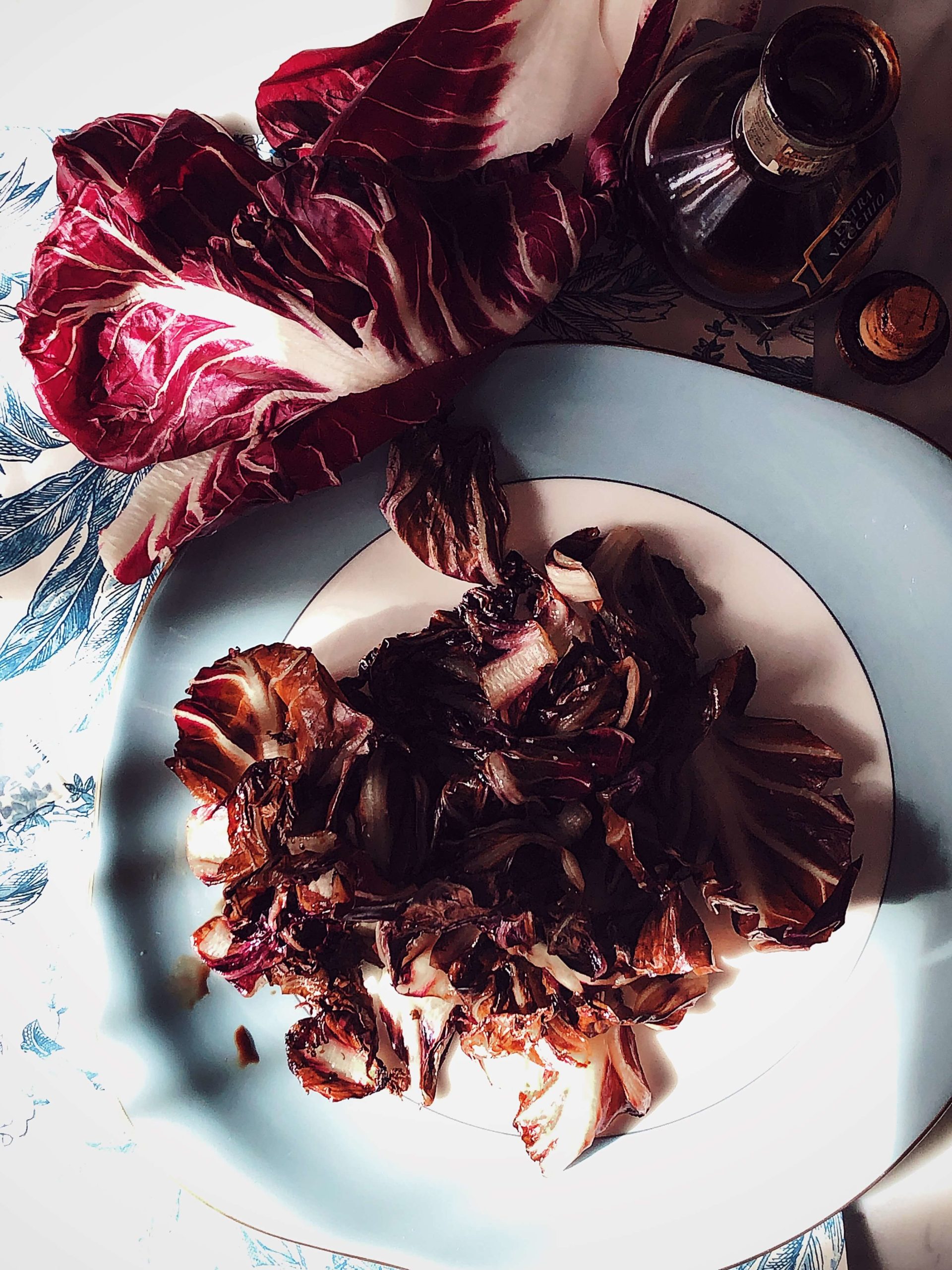 grilled radicchio with balsamic vinegar, raw leaves of radicchio, and a bottle of balsamic vinegar