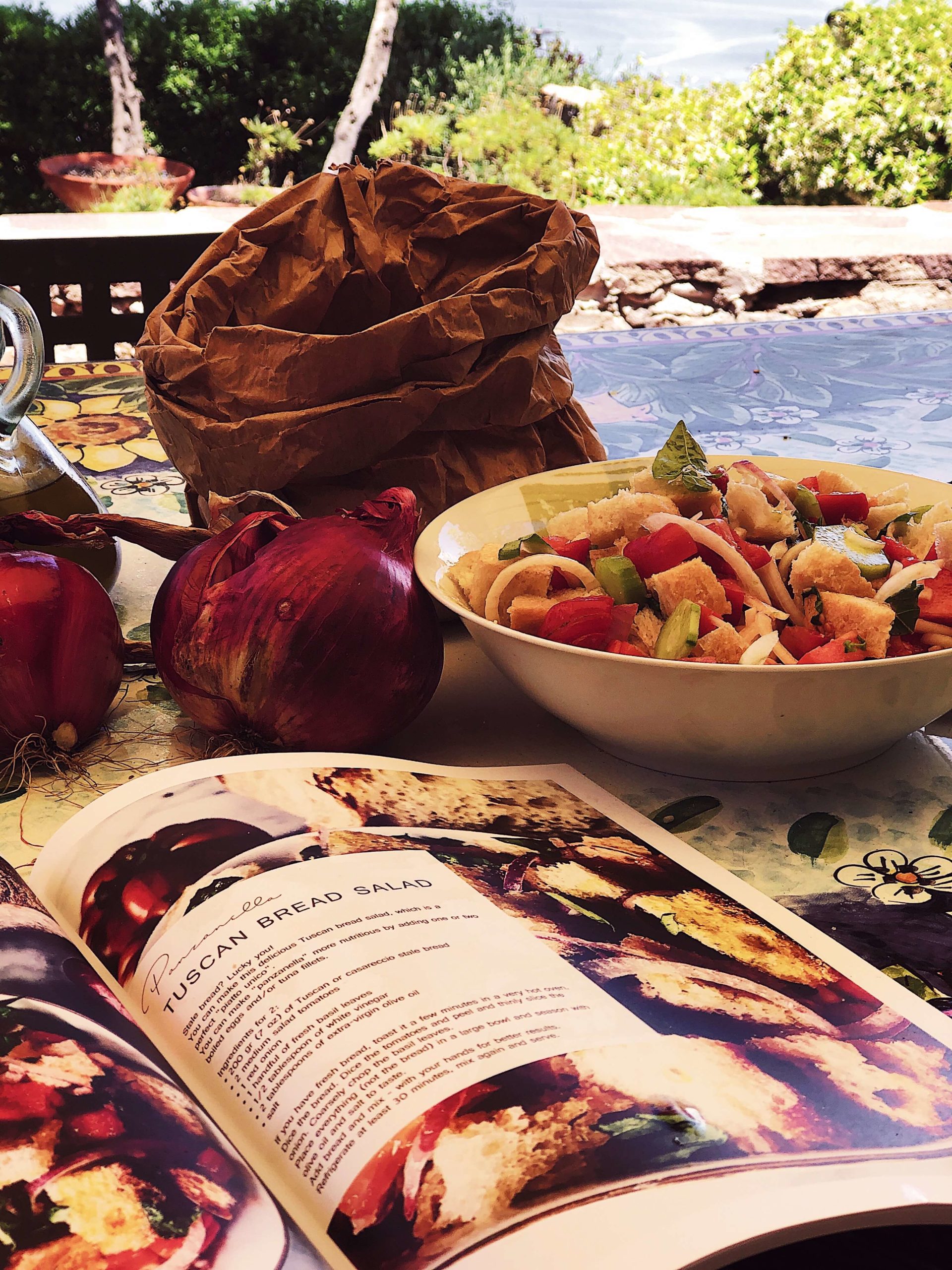 panzanella-italian-recipe-magazine panzanella salad in a white bowl next to the Simposio Italian cooking magazine
