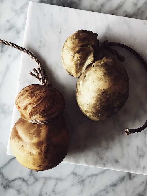 smoked scamorza cheeses on a marble surface