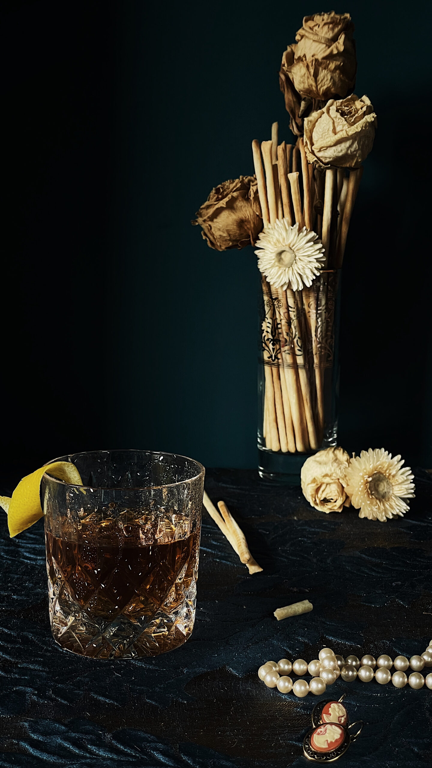 Vermouth di Torino in a glass with lemon zest garnish and grissini on the table